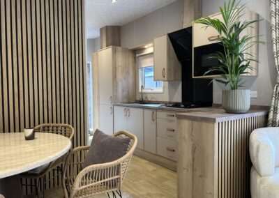 Nordbay chalet met grote ramen, lessenaarsdak en speelse gevelafwerking — moderne vakantiewoning met luxe interieur en veel lichtinval.